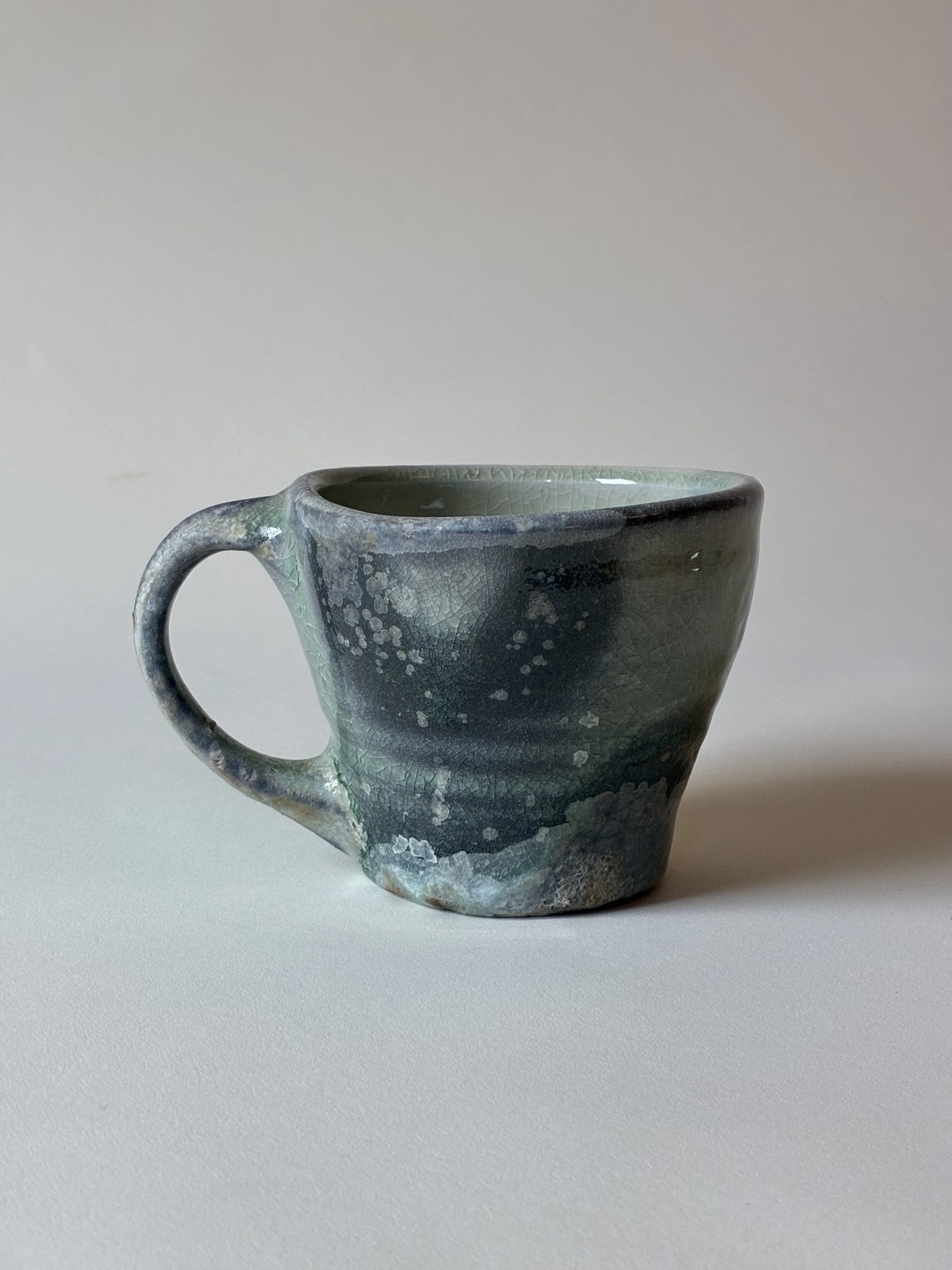 Mug with wax resist pattern and celadon glaze