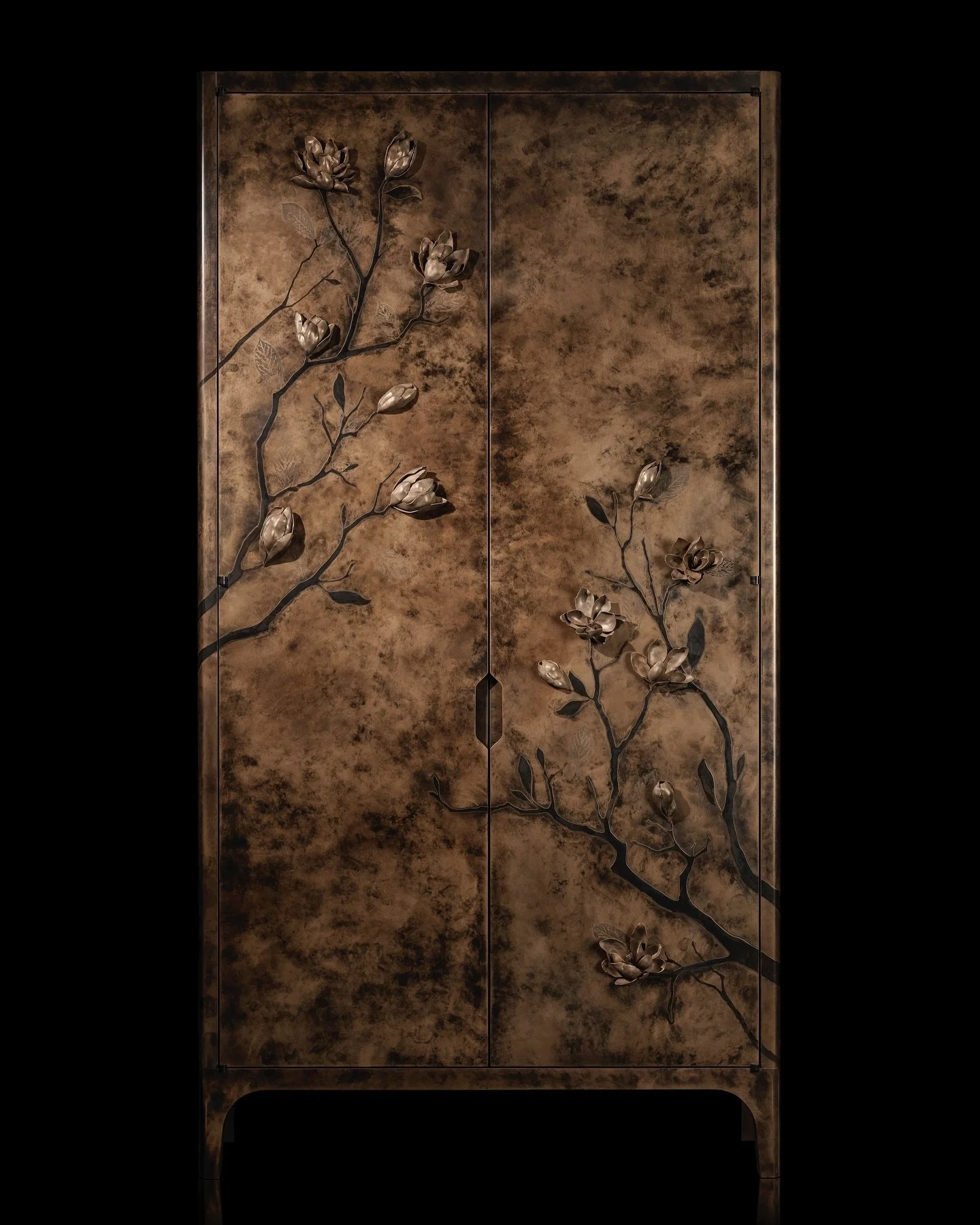 - BRONZE MAGNOLIA CABINETS -

A pair of cabinets finished in an elegant hand applied bronze magnolia design with a figured anegre and antique mirror interior, each flower carefully hand sculpted by our incredible artisans. Our maker&rsquo;s meticulou