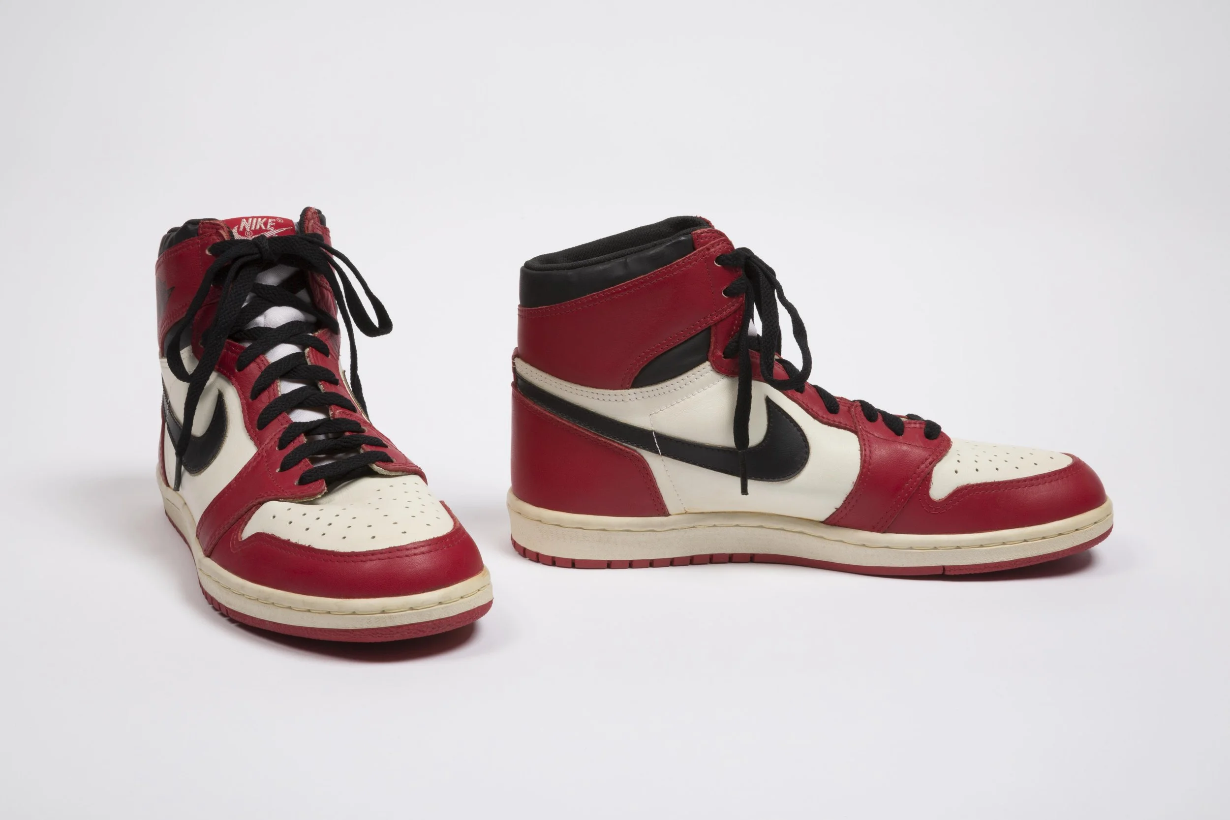 Nike, Air Jordan sneakers, red, white, and black leather, 1985, USA. Gift of Nike, Inc.