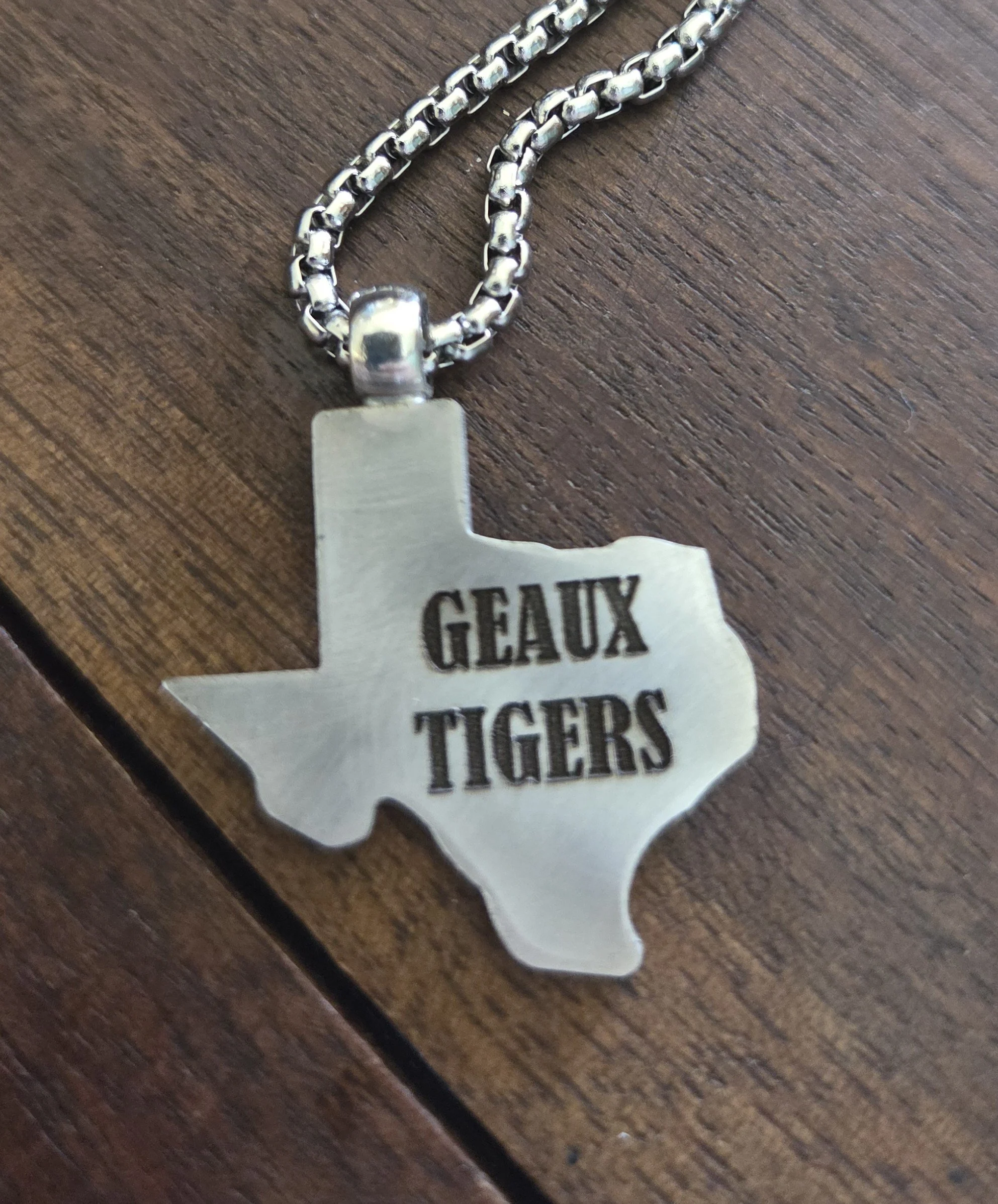 Texas shapes punched from vintage silver platters or spoon bowls. Every piece is then personalized with laser engraving. Geaux Tigers jewelry