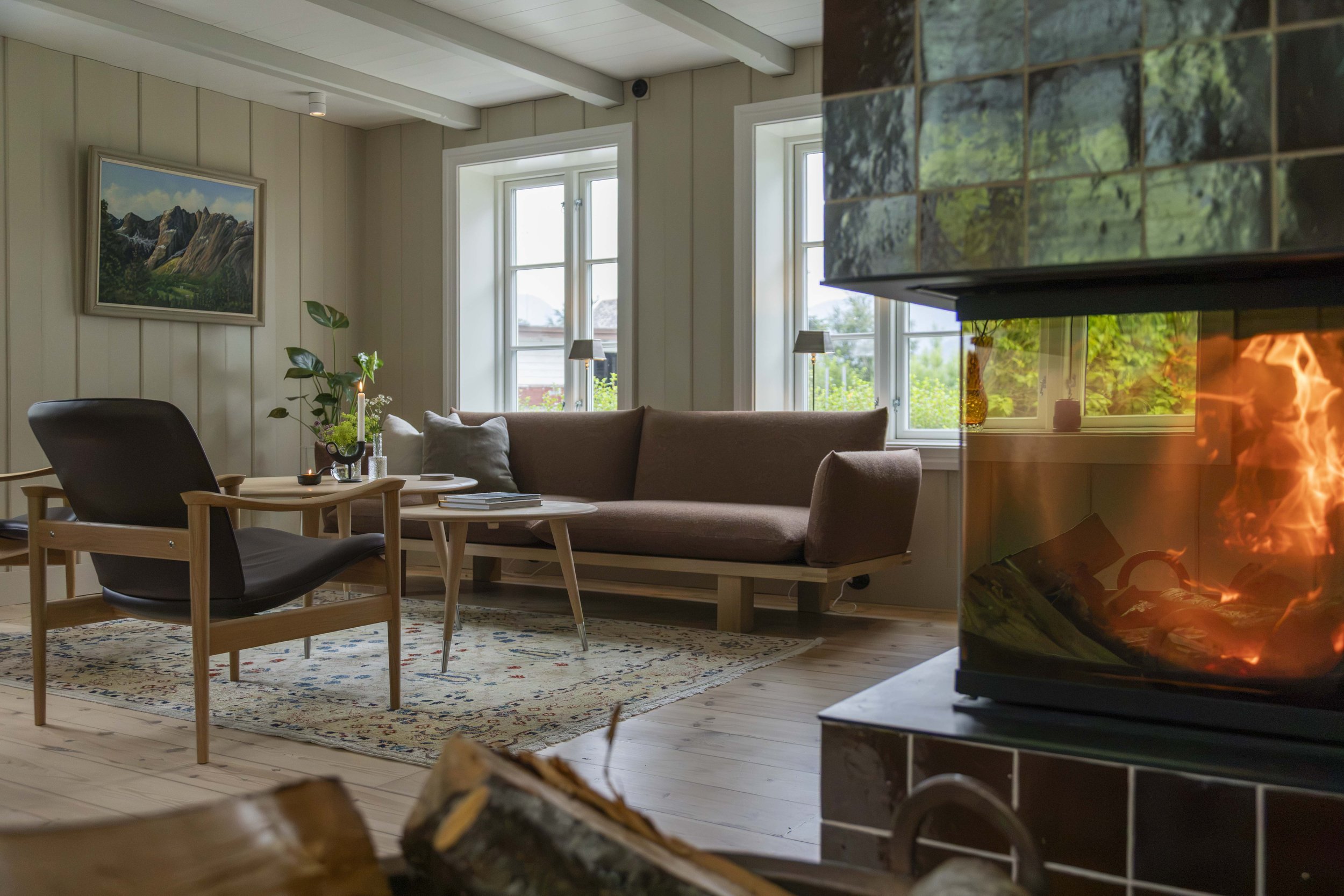 Sofa med fyr i peisen i Prestegårdshuset