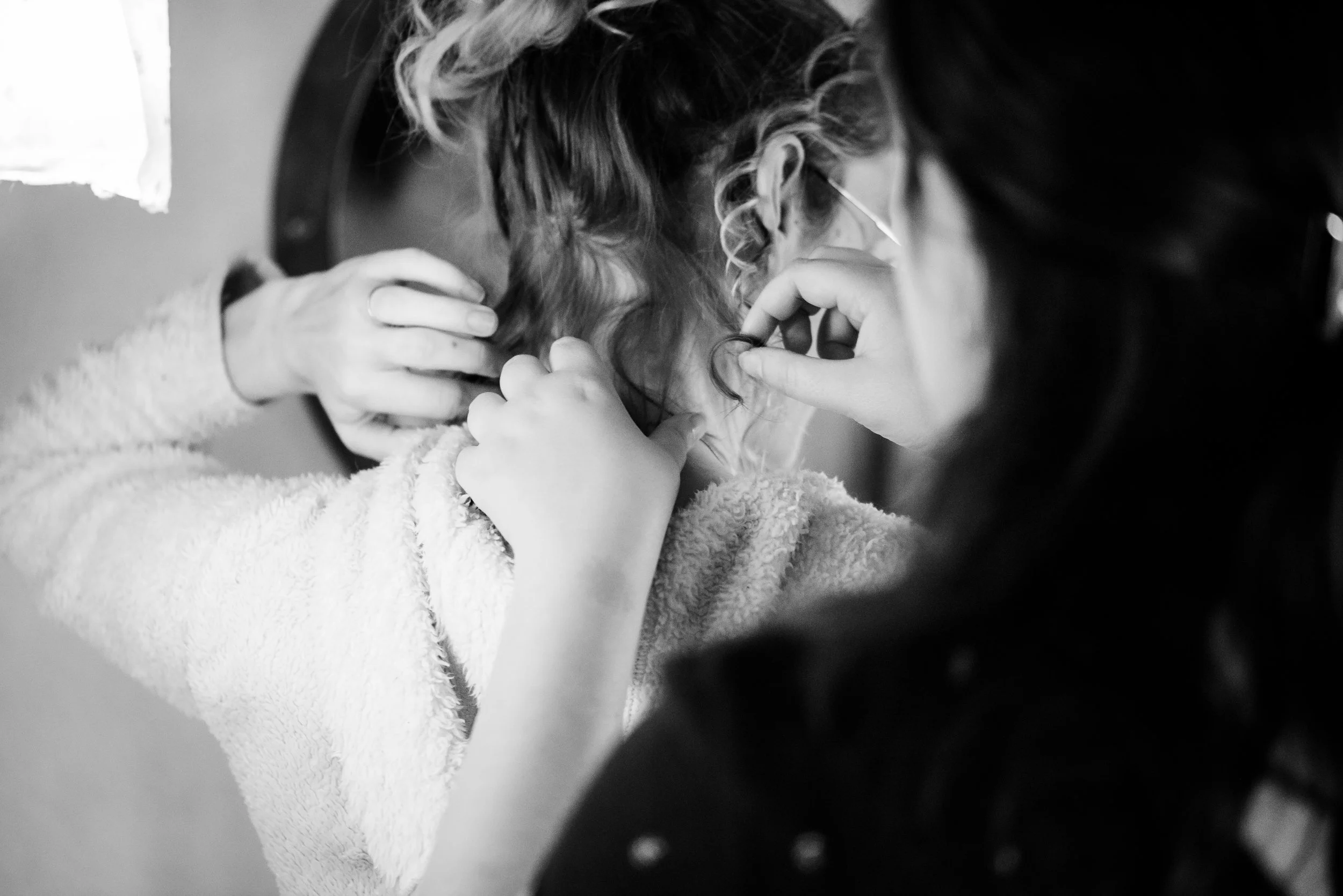 Une personne qui pratique une epination ou une pratique similaire, inclinée en avant avec deux autres personnes qui l'aident en la soutenant et en la manipulant, dans un contexte médical ou thérapeutique.