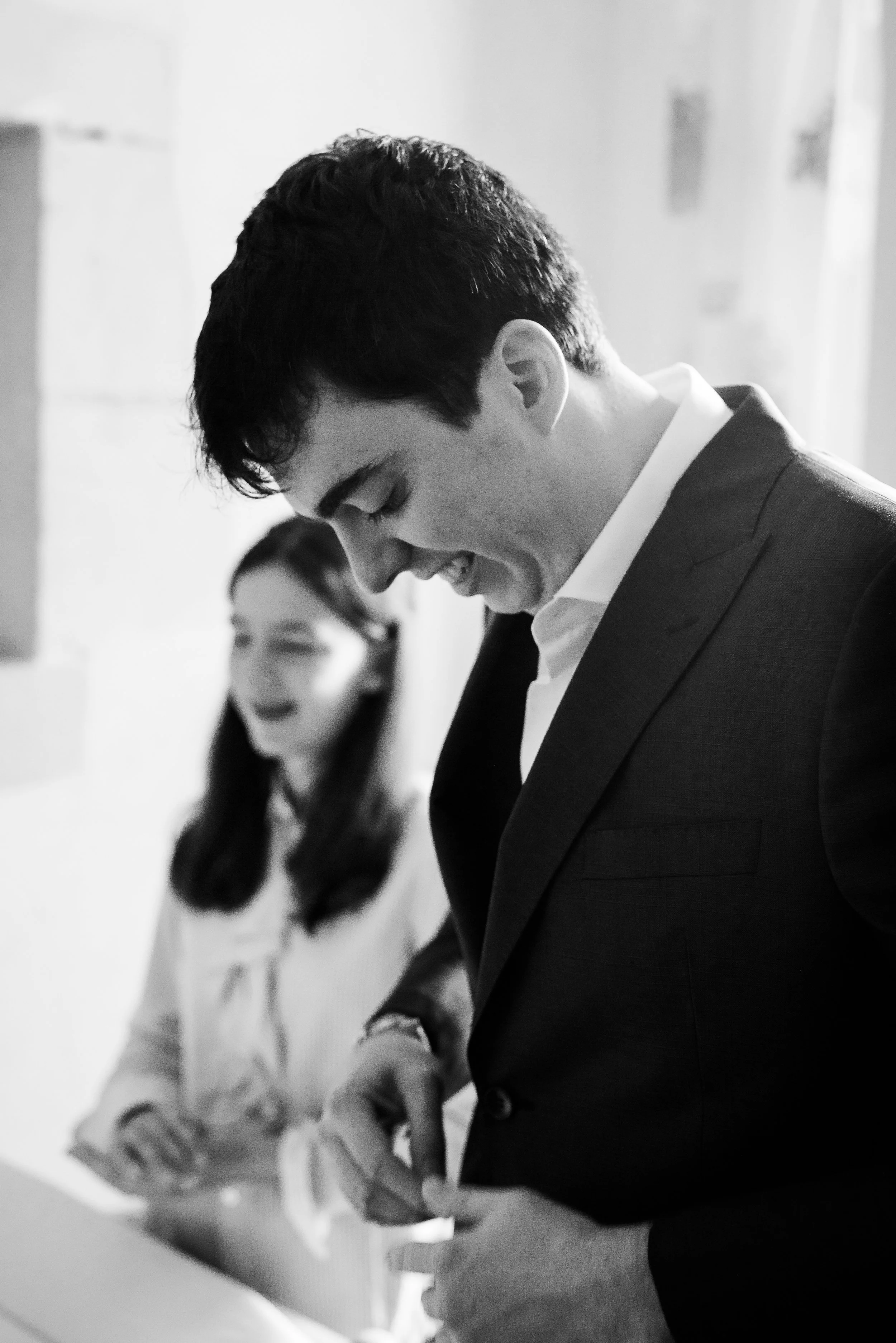 Deux personnes, un homme en costume noir et une femme en blanc, tiennent une plaque lors d'un événement.