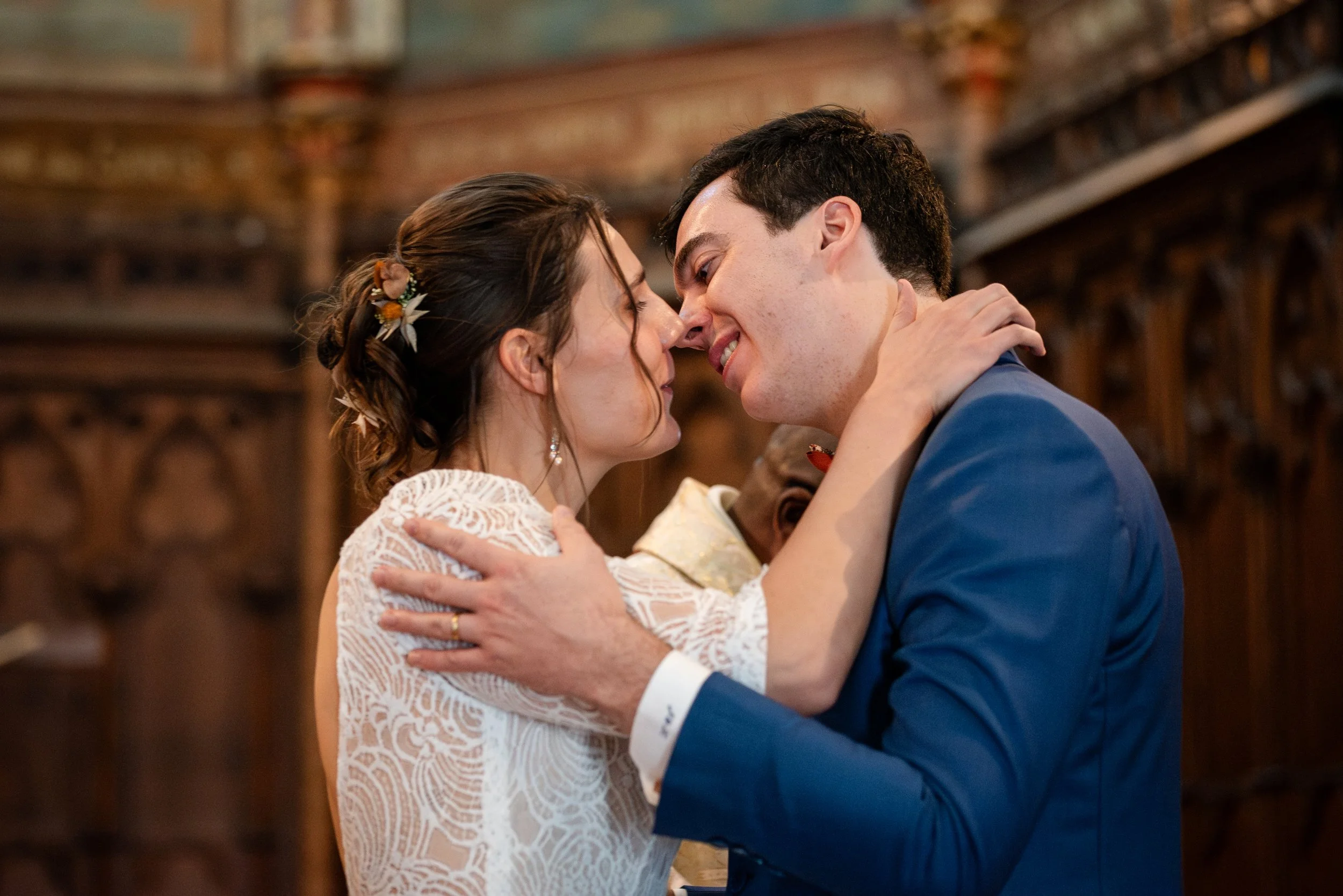 Un couple marié s'embrasse tendrement lors de leur mariage dans une église en bois.
