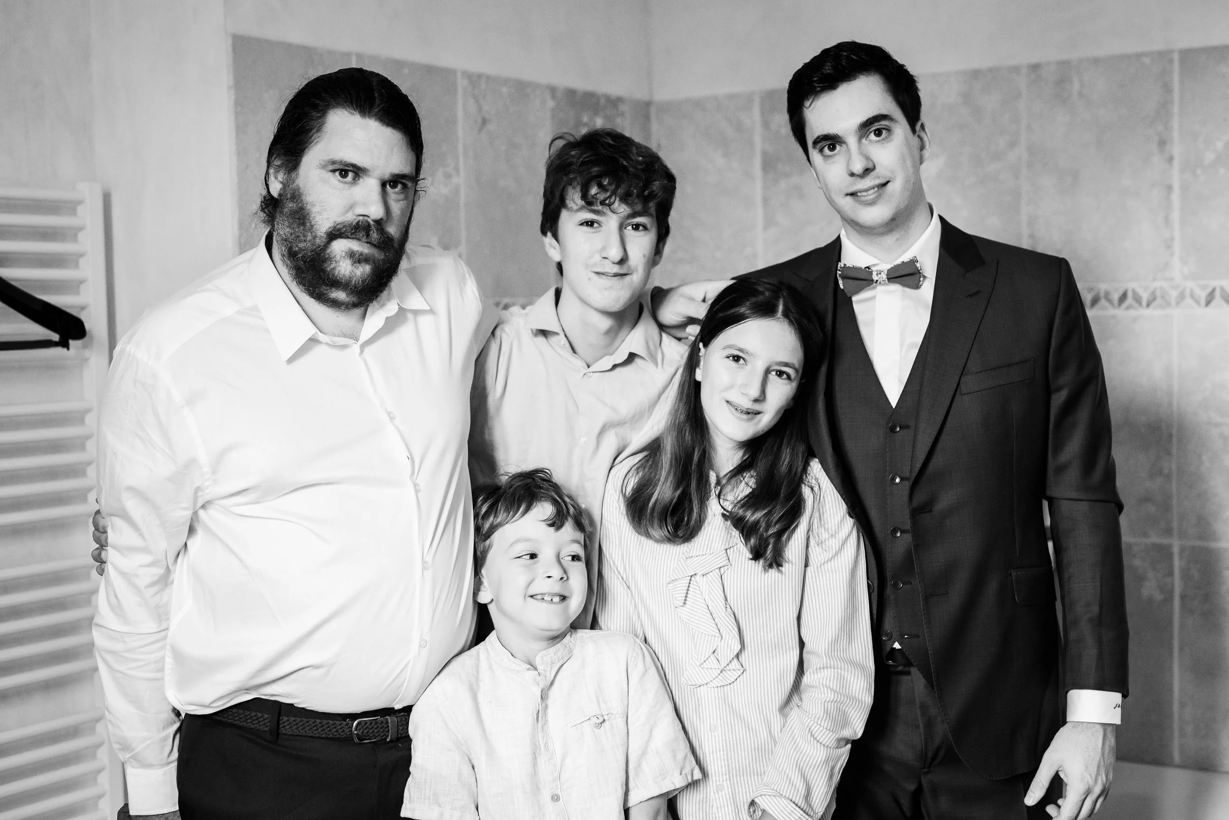 Groupe de cinq personnes, quatre adultes et deux enfants, posant pour une photo en noir et blanc dans un intérieur.