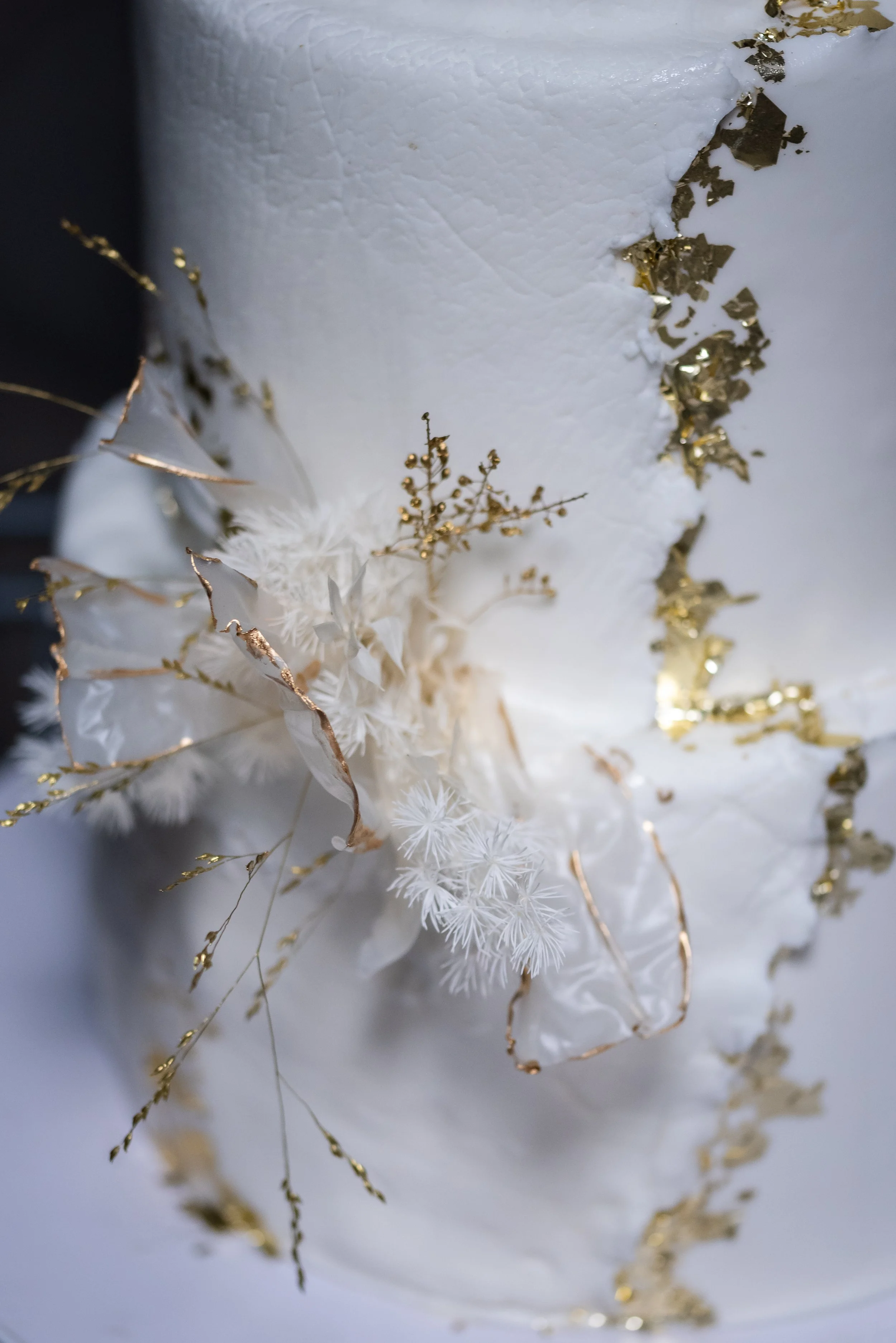 Décor de Noël blanc et or avec des branches et des éléments en fausse neige.