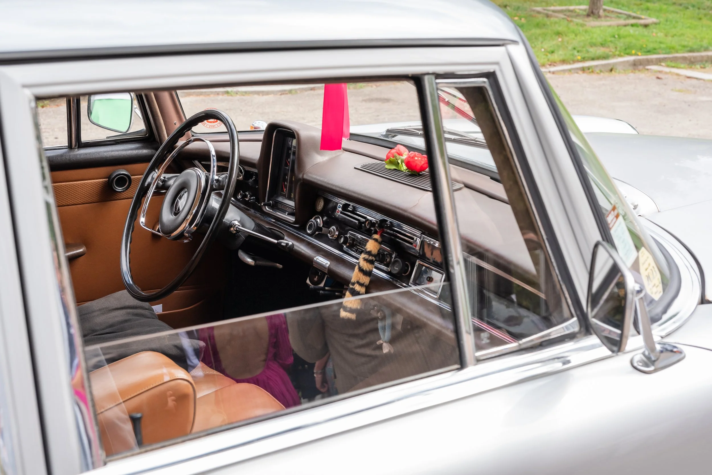 Intérieur d'une voiture ancienne avec des décorations florales, vue à travers la vitre
