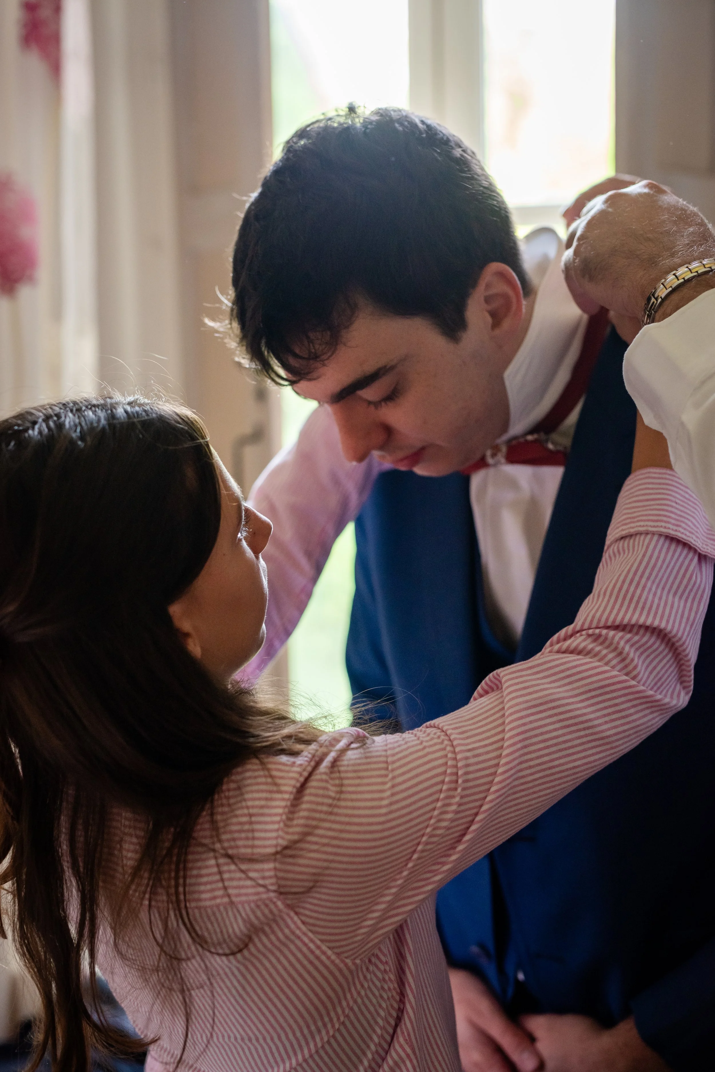 Une femme et un homme dans une interaction intime, la femme a les bras levés et regarde l'homme, qui platine ses épaules et s'incline vers elle.