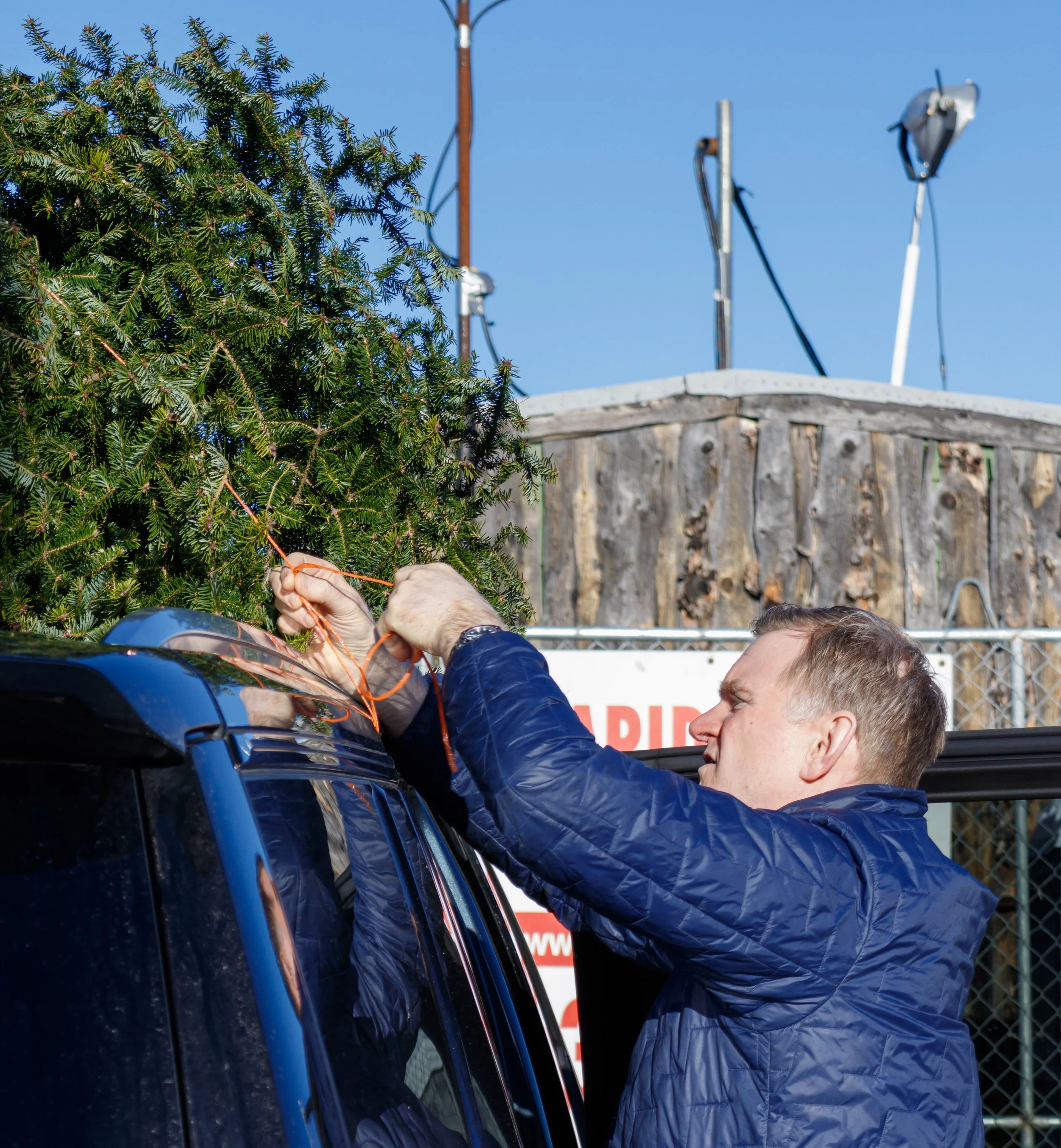 Tom Crockett ties down his newly purchased Christmas tree from Fresh Christmas Trees on Horton Rd. in Calgary on Monday, Nov. 29, 2021. 