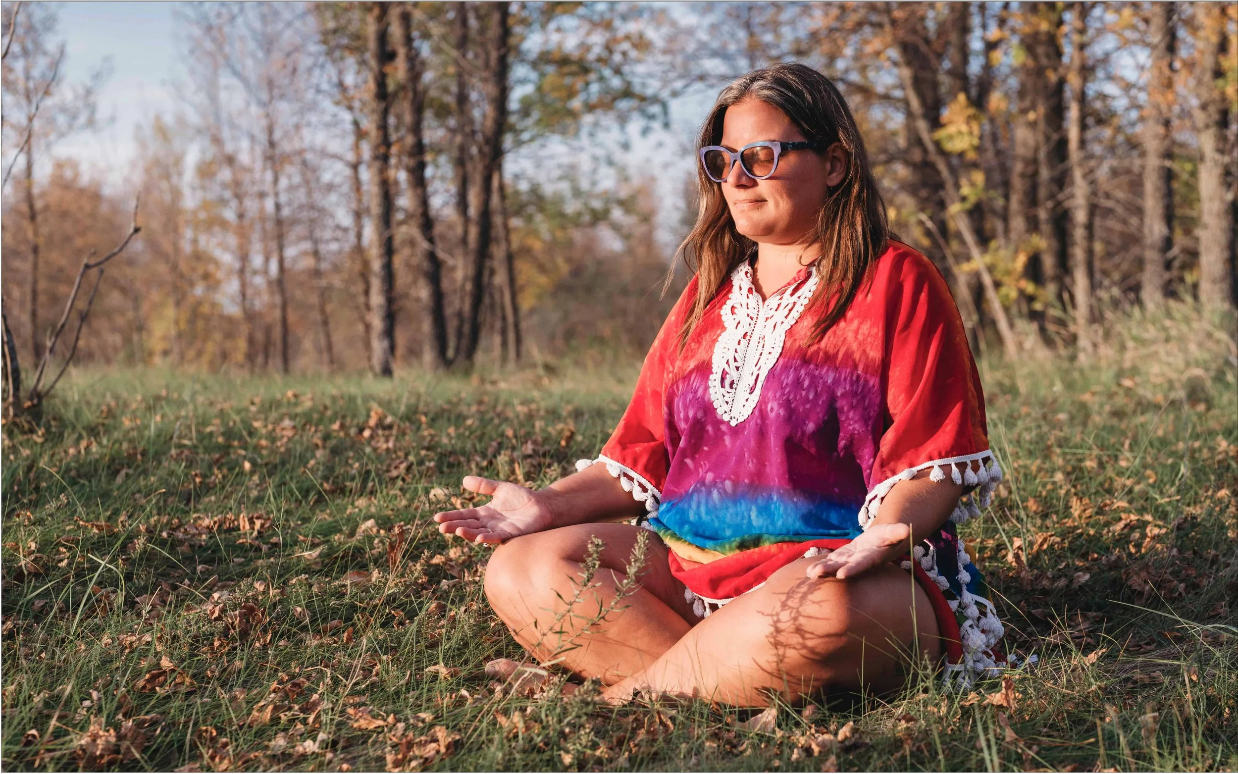 Substance use therapist meditating in a forest with sun rays basking her body