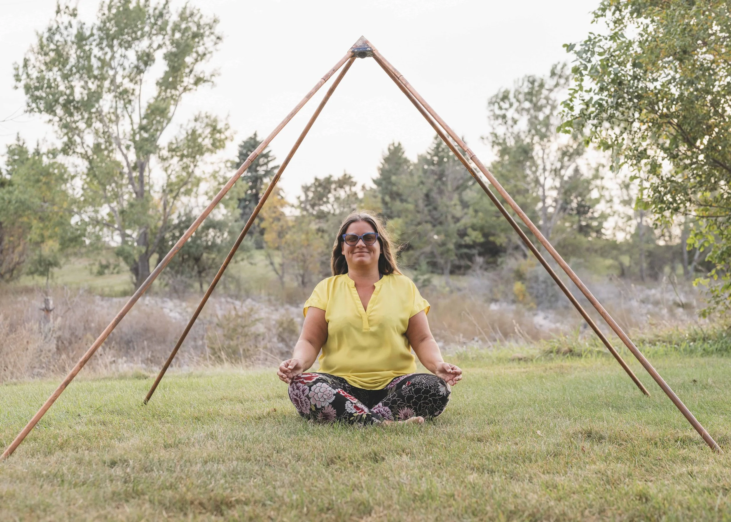 therapist, Victoria Gore seated cross legged in the forest