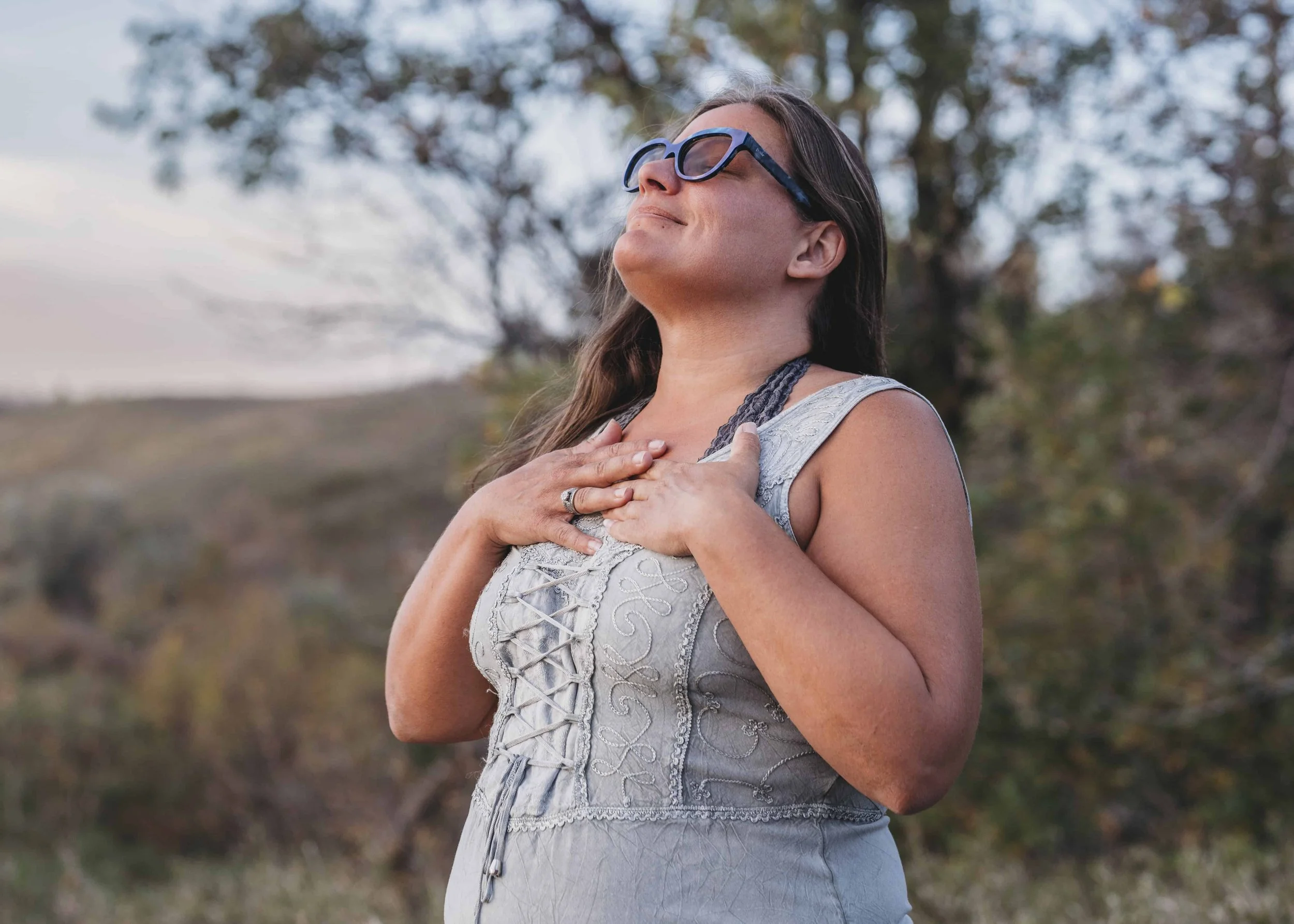 therapist, Victoria Gore smiling while placing her hands on her chest to show she's feeling at peace