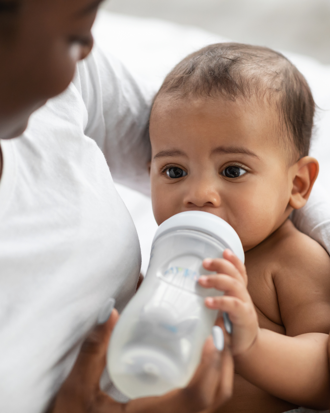 Mom feeding newborn a bottle