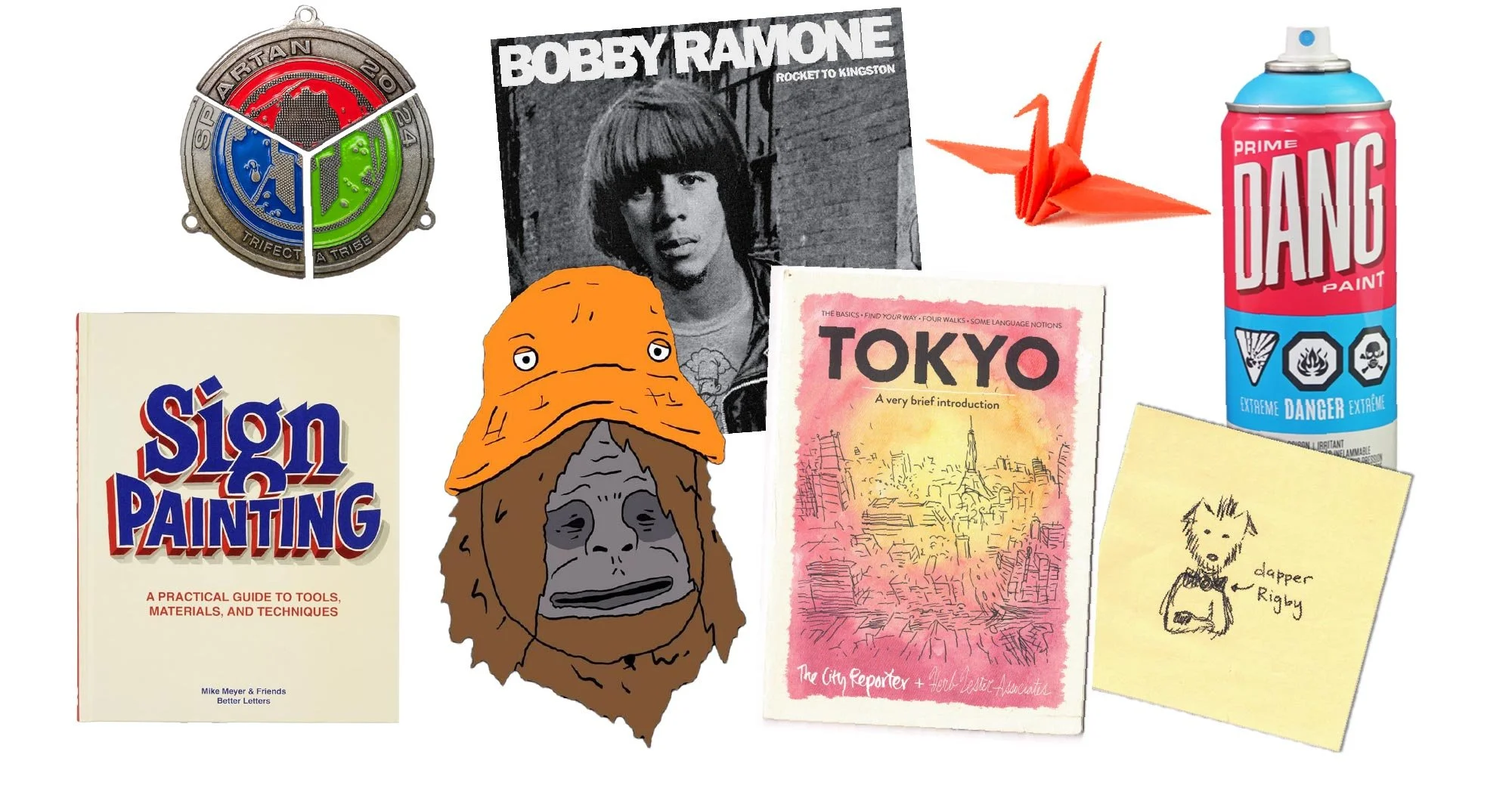 A collection of various objects including a circular medal, a black and white photograph of a young man with medium-length hair, a small red origami crane, a pink and blue spray paint can, a book titled 'Sign Painting,' a drawing of a face with an orange hat, a book titled 'Tokyo,' a sketch of a dog labeled 'dapper Rigby,' and a book cover with a portrait of Bobby Ramtone.