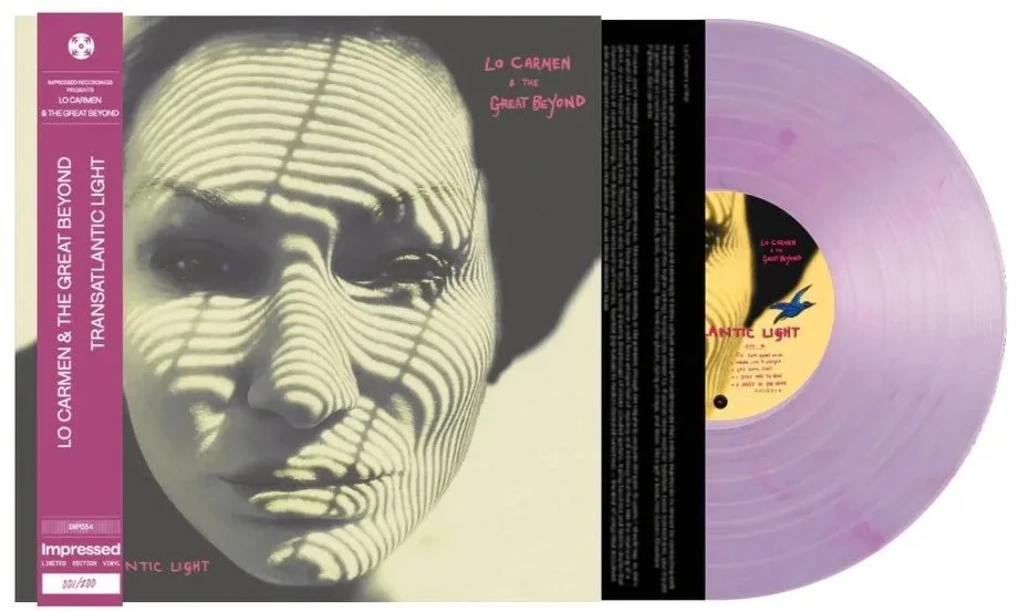 Pink vinyl record with an album cover featuring a black and white portrait of a woman's face with shadow patterns across it, titled 'Lo Carmen & The Great Beyond - Transatlantic Light'.