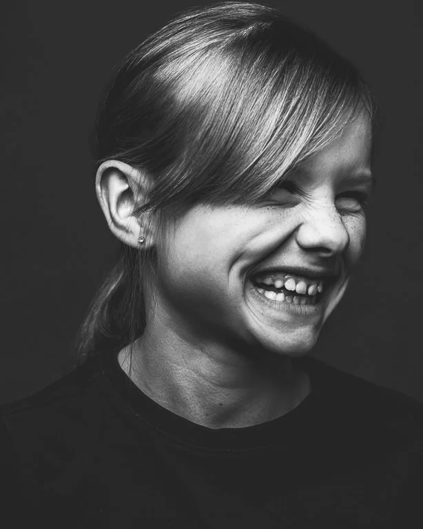 Spontane blikken tijdens een fotoshoot voor een kind in het zwart wit. Pure emotie