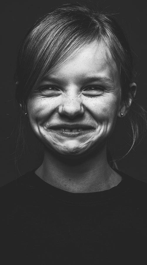 Zwart-wit portret van meisje in studio, drieluik met verschillende gezichtsuitdrukkingen