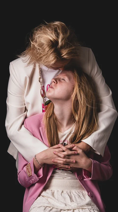 Familieportret van moeder en dochter met warme, spontane interactie in de studio