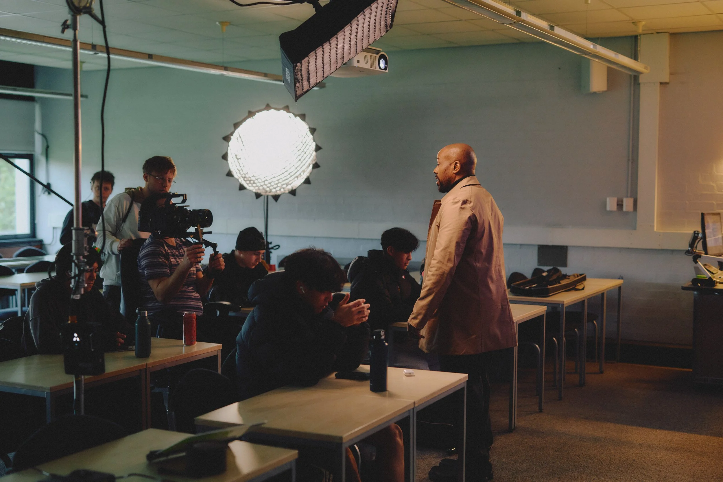 behind the scenes of a corporate production. Featuring a cast and crew, lighting and camera inside of a classroom