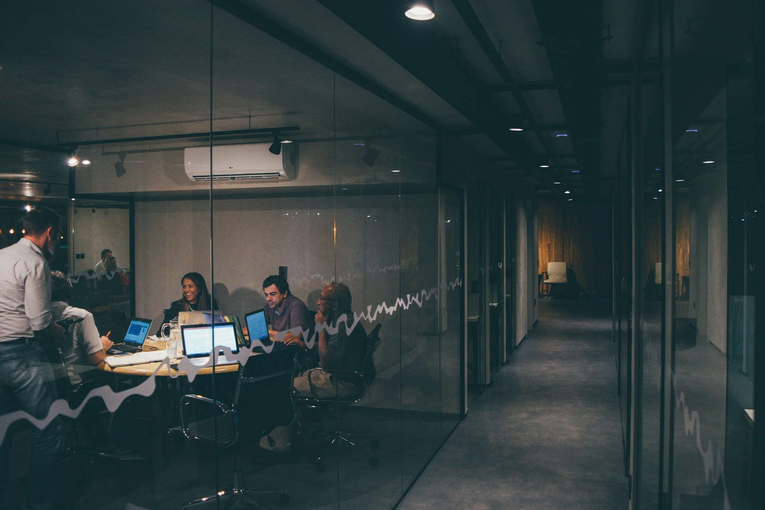 A project team working together in a meeting room at night