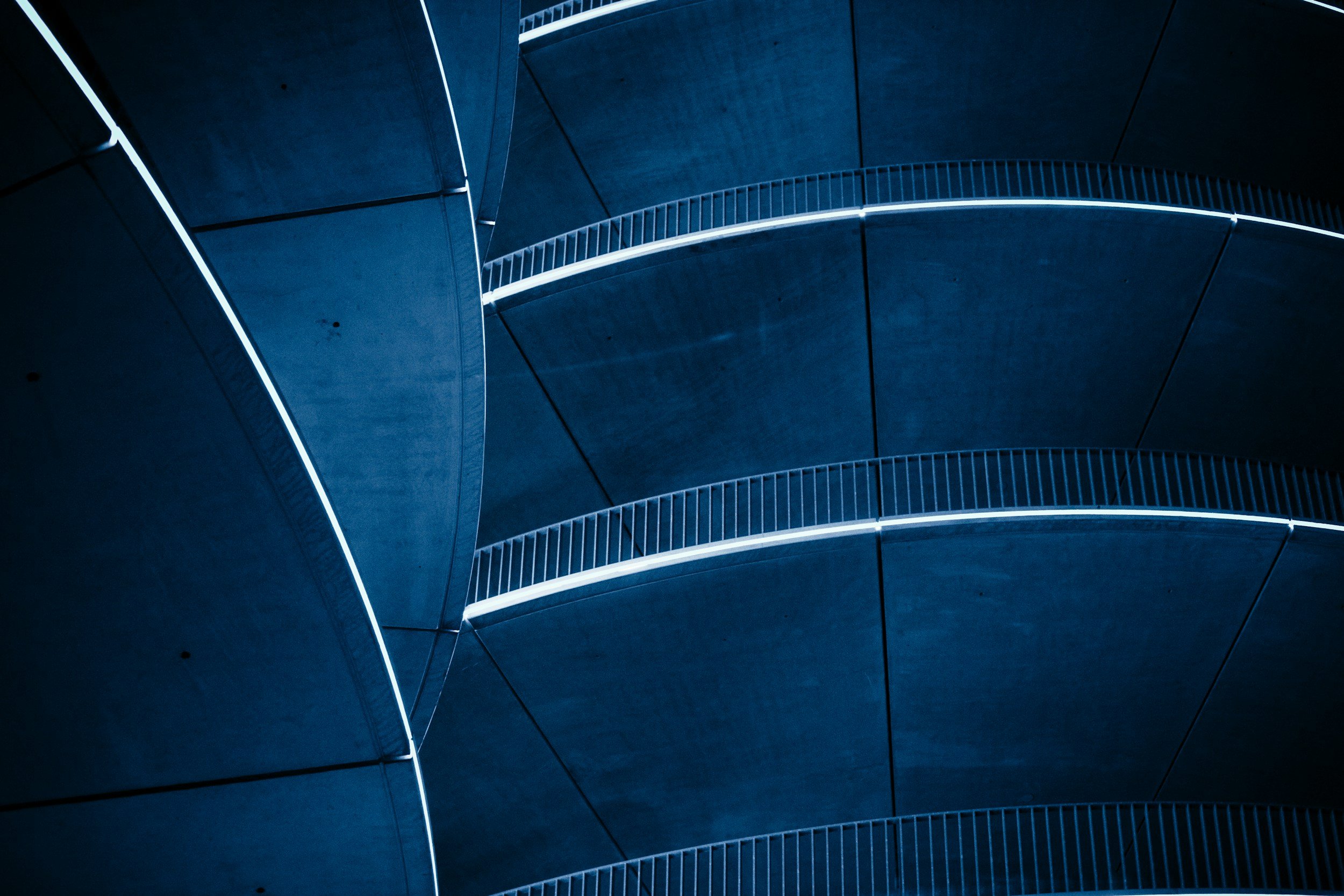 Curved lines of a deep blue modern building converging