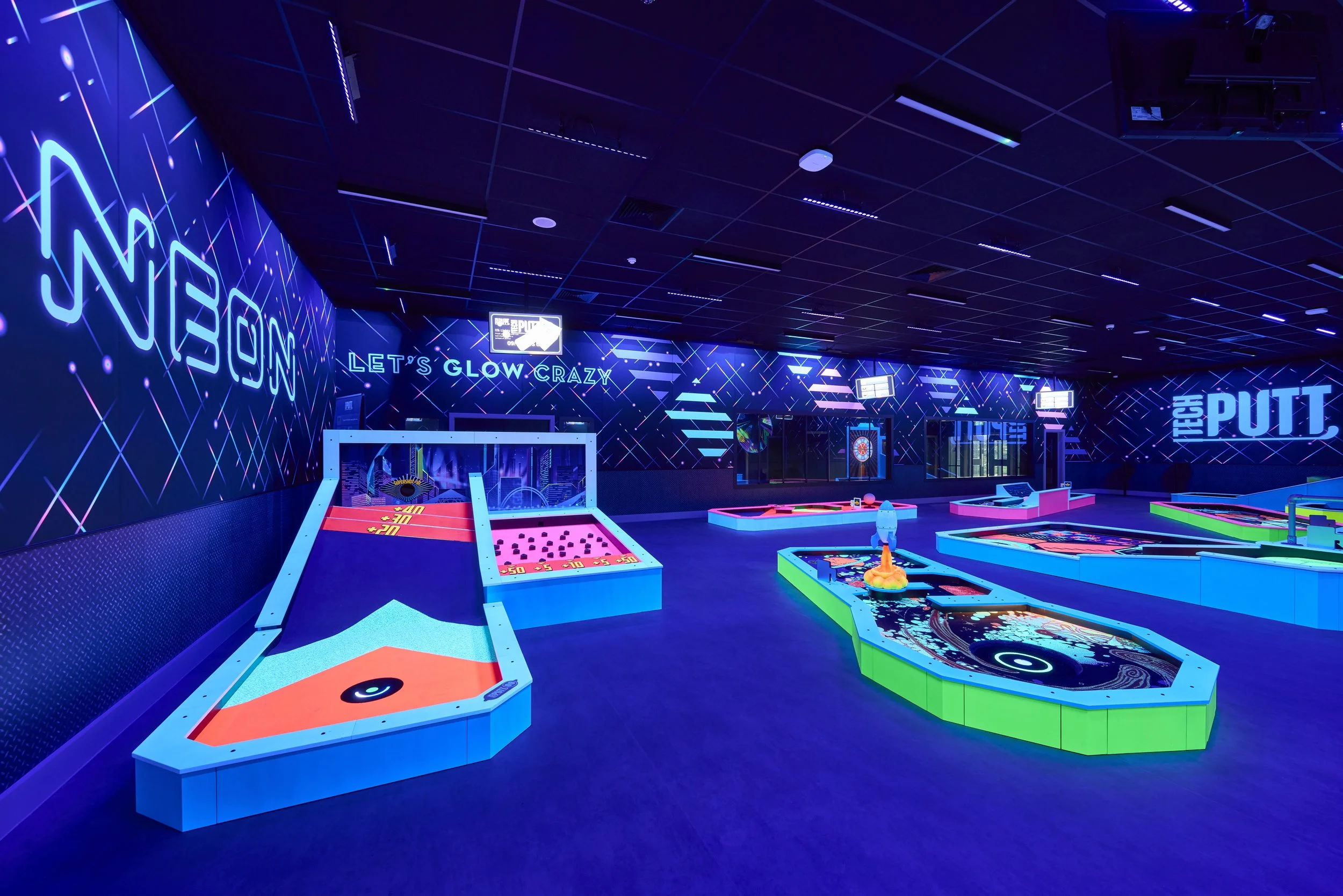 360Golf smart mini golf installation at Butlin’s, featuring colourful interactive holes, digital screens and neon lighting.