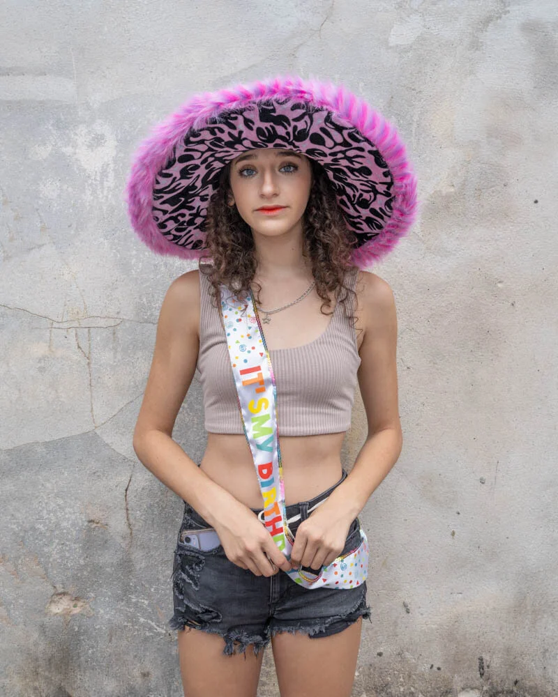 The Understory by Lisa Mahar: girl in a pink fur hat against a concrete wall, color photograph