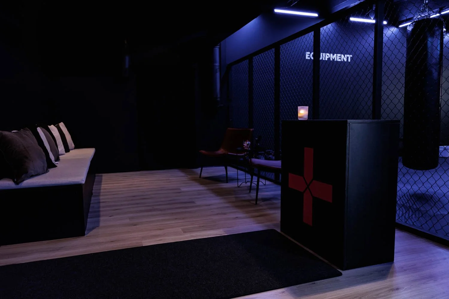 Hieno, pimeä vastaanottoalue tai odotustila, jossa on sohva, kaksi tuolia ja monivärinen valaistus