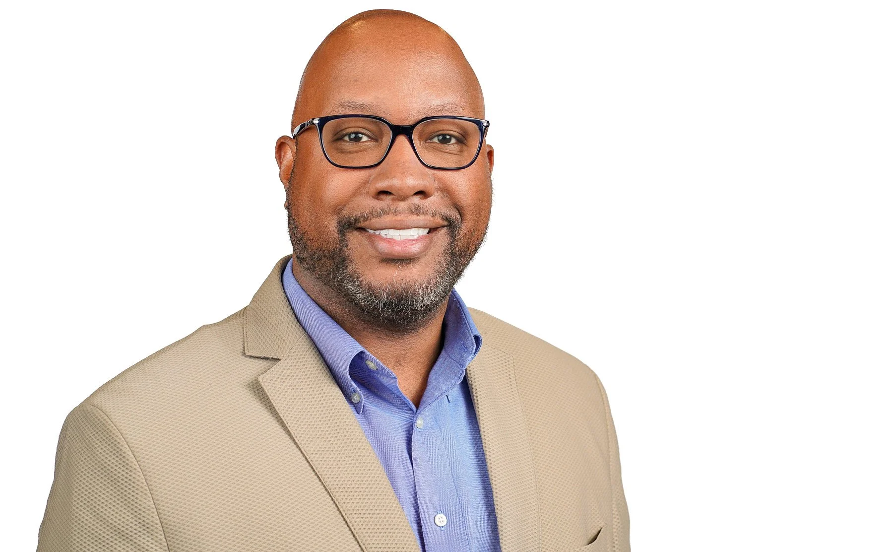 Headshot of a bald African American man wearing glasses, a blue button up, and a tan overcoat.