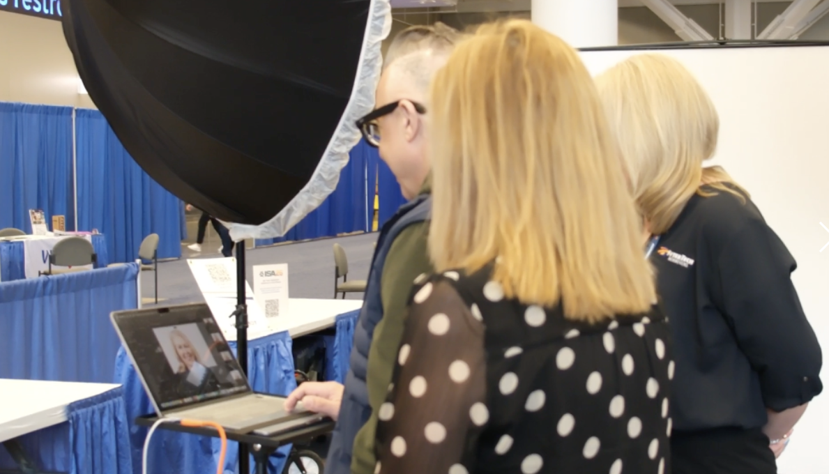 Howard Myles looking at headshot photos on his laptop with two female clients