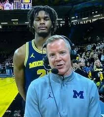 Morez Johnson staring stoically into the camera behind Coach Dusty May