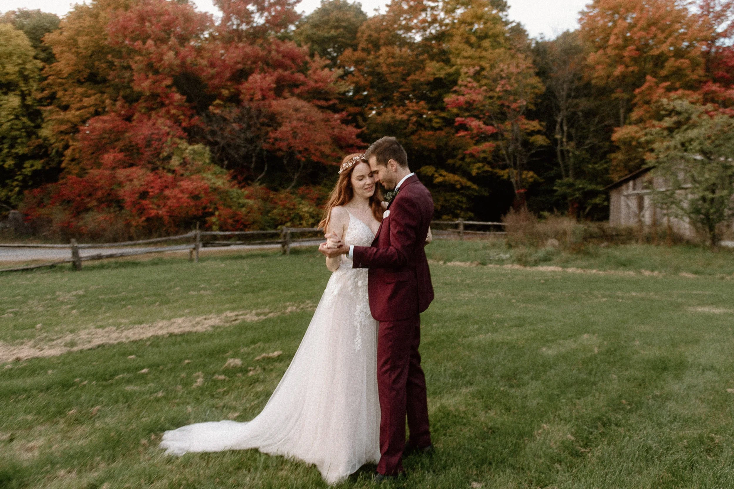 Bride and groom slow dancing in a field