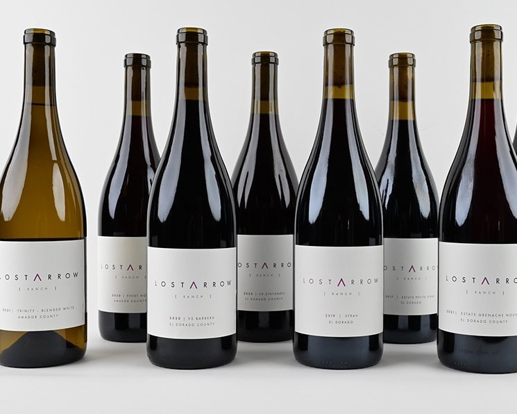 A photograph of 8 Lost Arrow Ranch wine bottles arranged in a row.