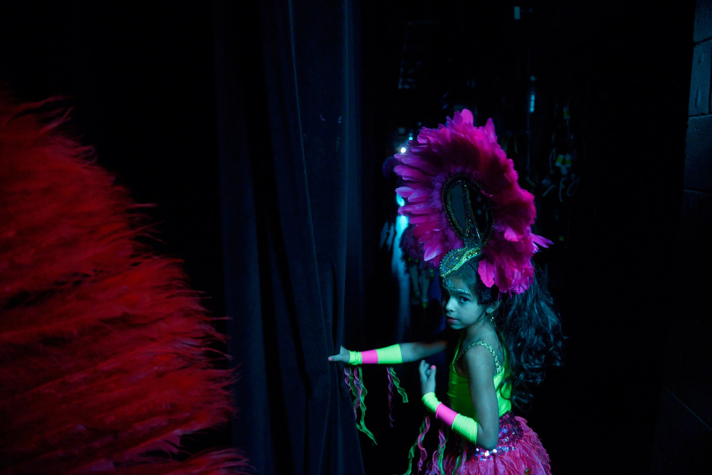 Lorena Hartstein, a girl performing in the Group Cultural Latinos En Rochester Hispanic Heritage Carnival Show widens the backstage curtain passageway for her fellow performers to get through, behind the MainStage of the Kodak Center, on October 2nd,