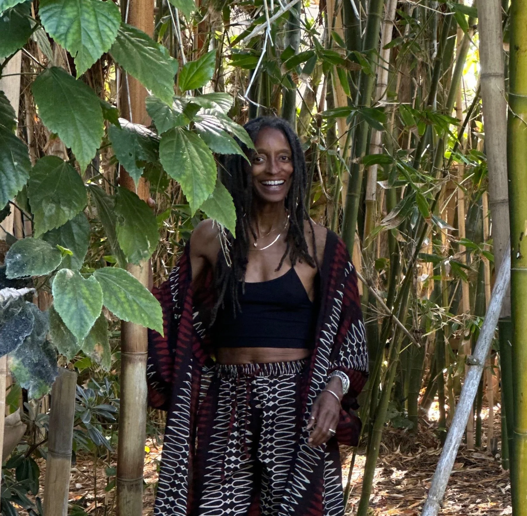 Cheryl Freeman, founder of Tamra Copper LA, smiling among bamboo and greenery.