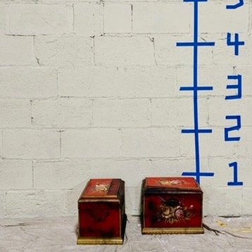 two red floral display boxes against white wall
