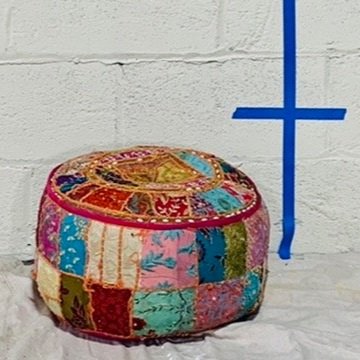 multicolor quilted pouf against white wall