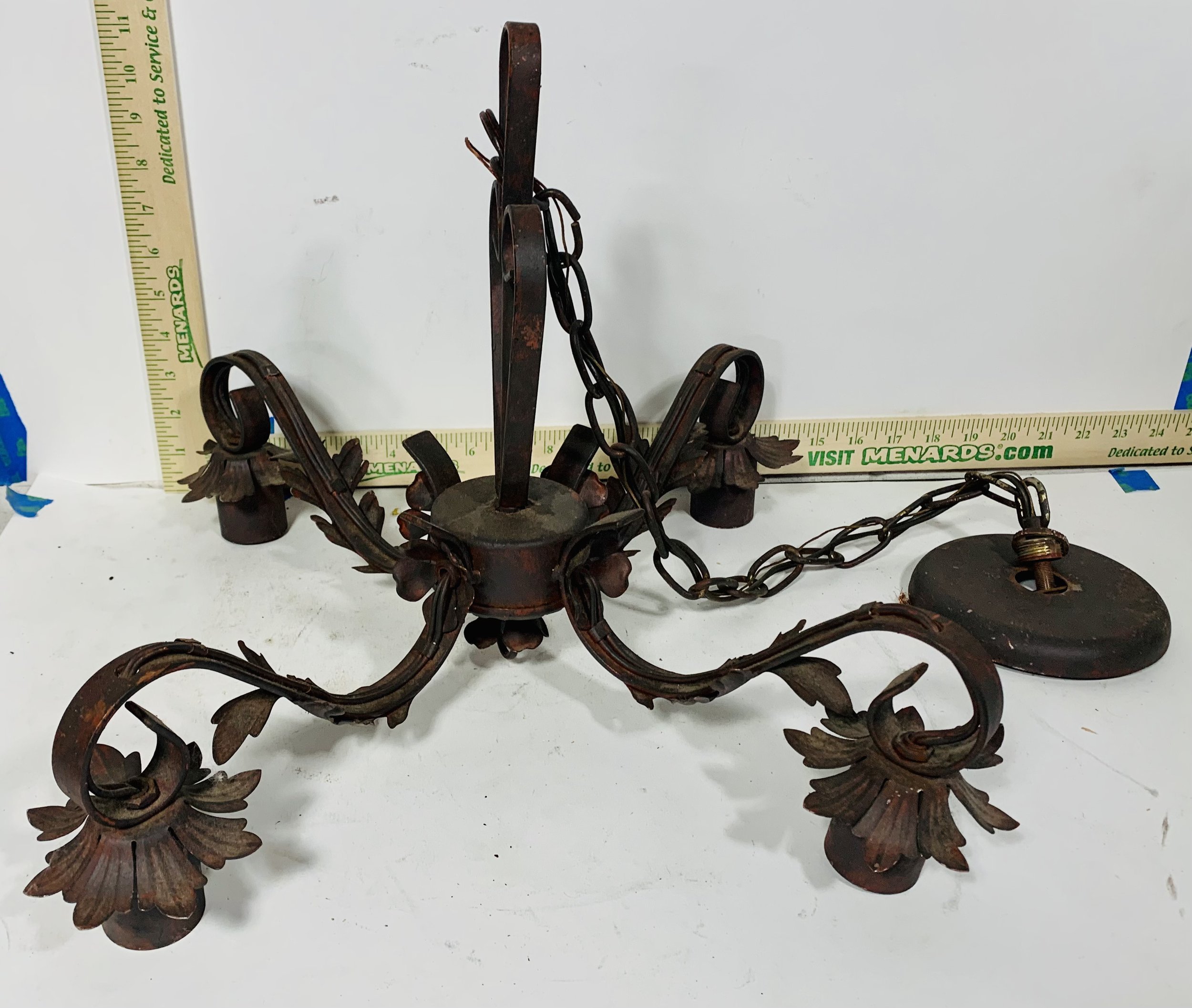 ornate metal chandelier with 4 candles or bulbs against white background with rulers