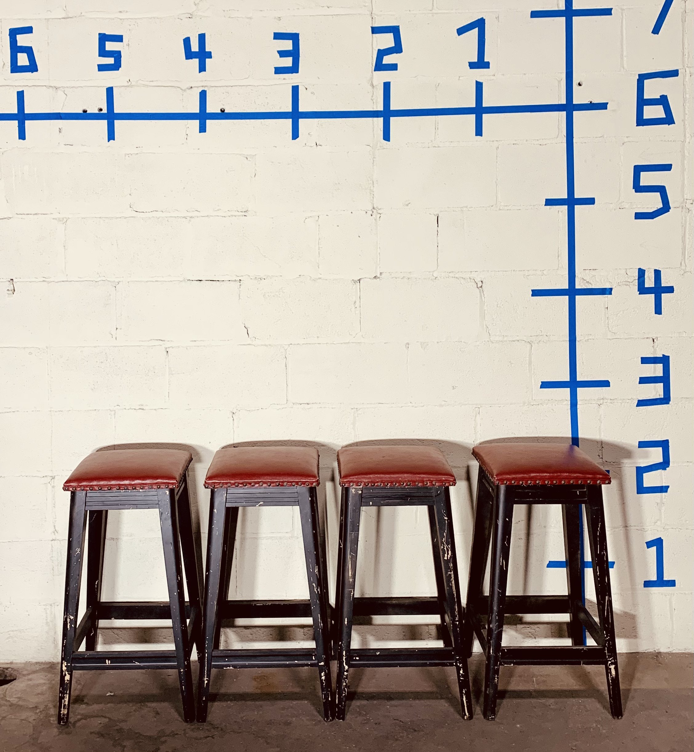 four square red bar stools against wall with dimensions