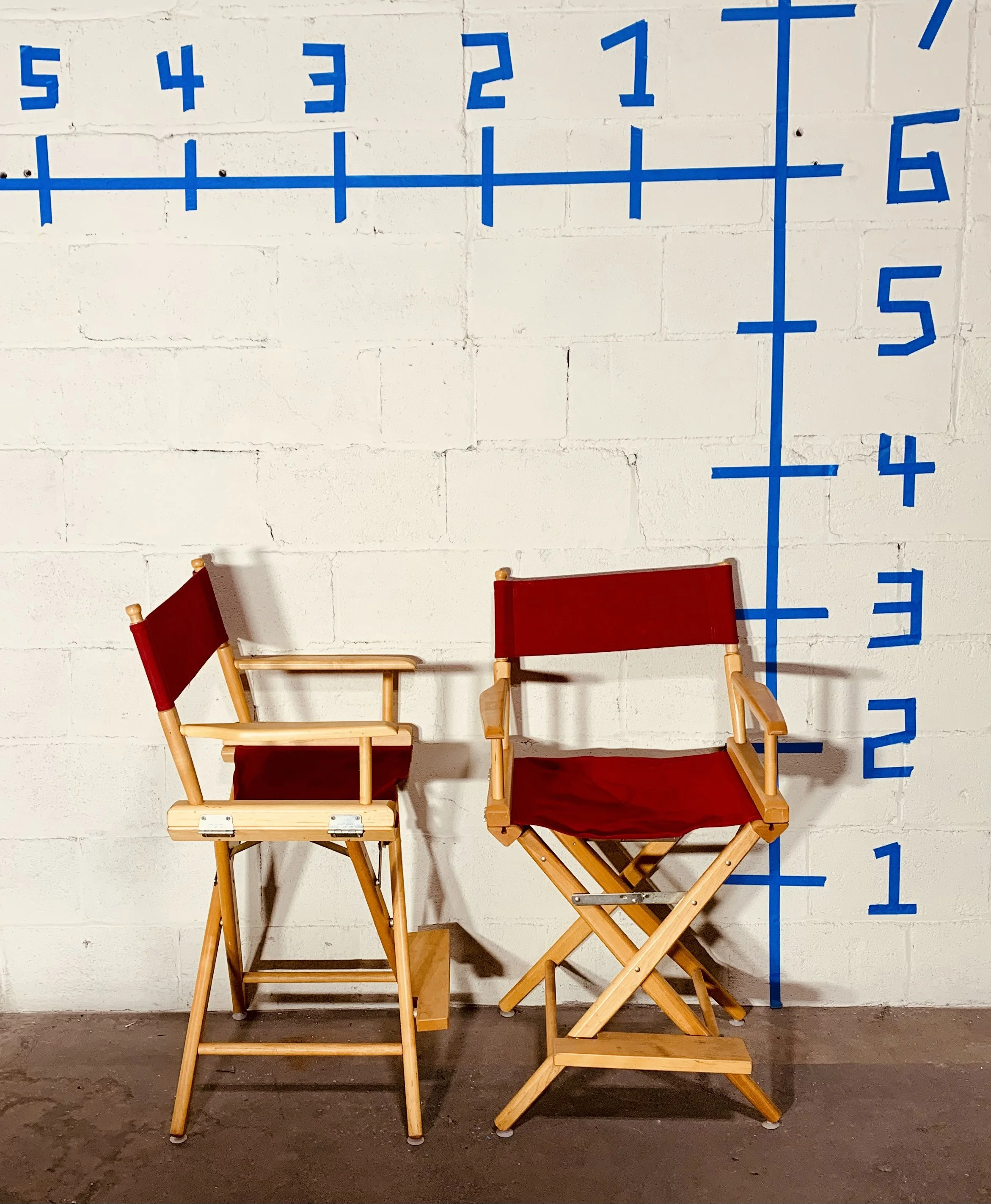 red director chairs against wall with dimensions