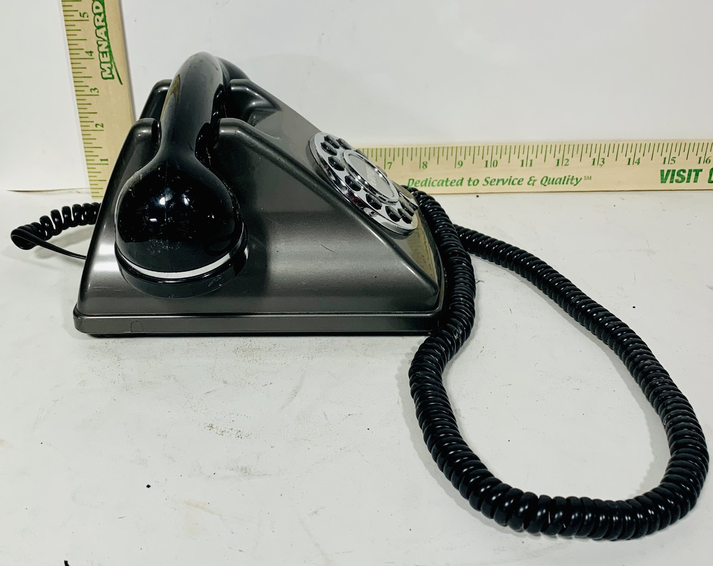 side view black rotary phone with black cord