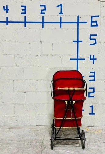 back view vintage red pram against white wall with dimensions