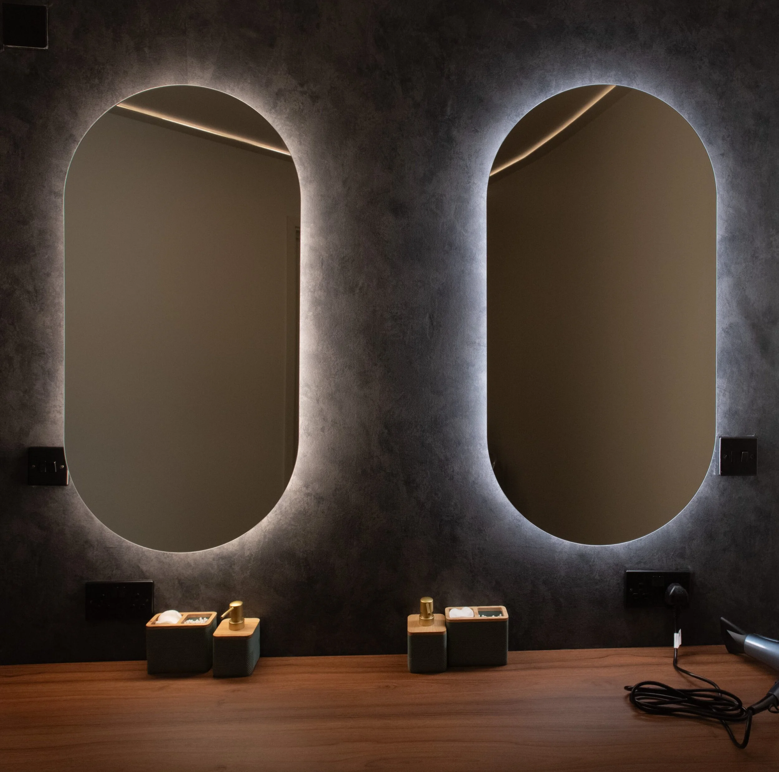 Modern vanity area at Being Wellness Centre in St Albans, featuring illuminated mirrors, premium guest toiletries, fresh towels and elegant timber finishes within a contemporary wellness space.