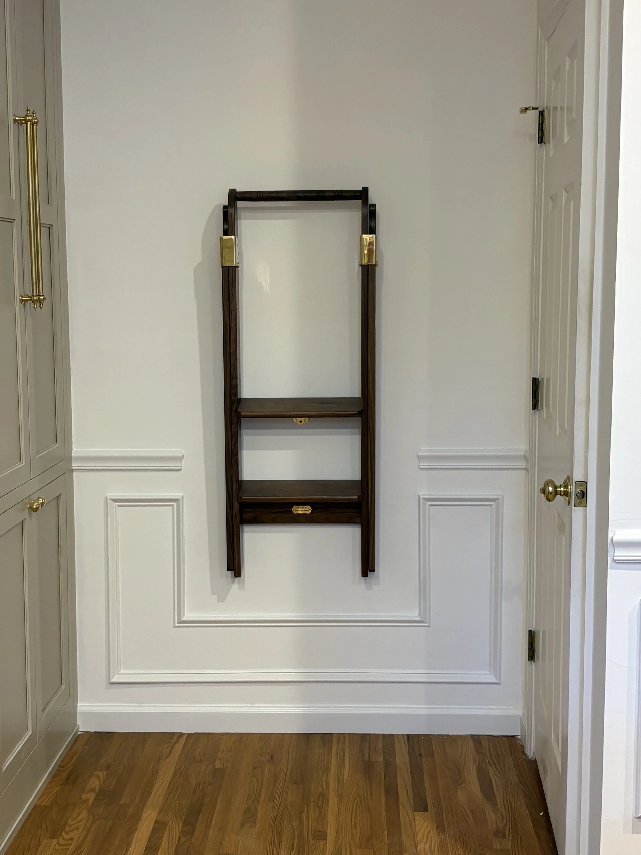 Mahogany ladder mounted on the wall as a featured presentation in a tall kitchen 