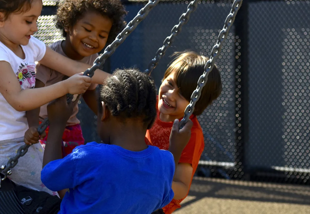 Children playing on a tire swing at LETC