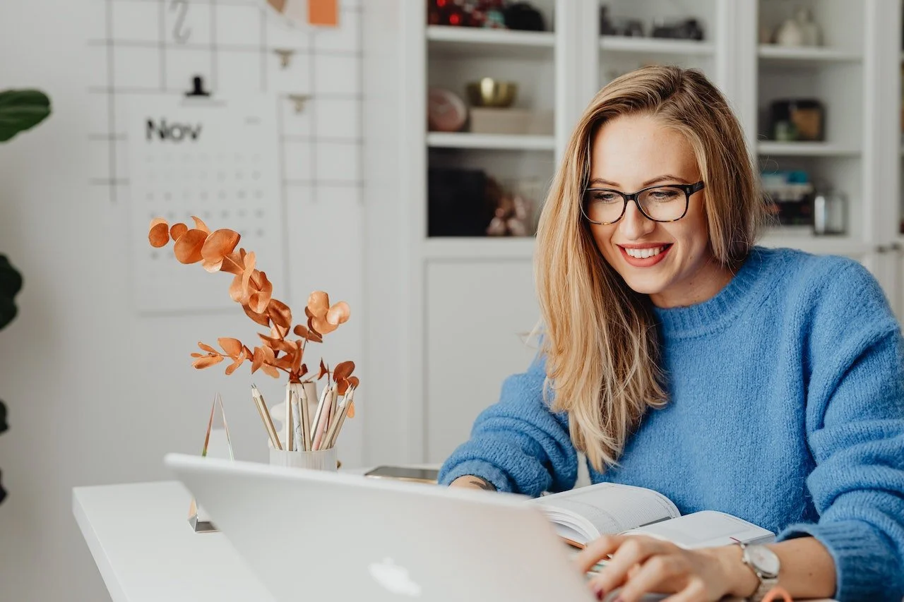 Virtual assistant smiling while working on her computer