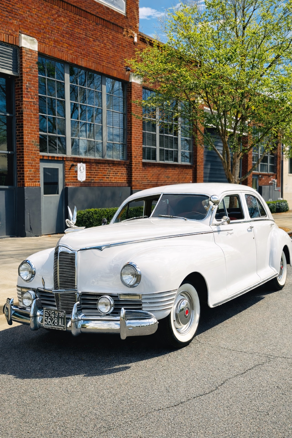 Sunlit urban scene with classic Packard Clipper.png