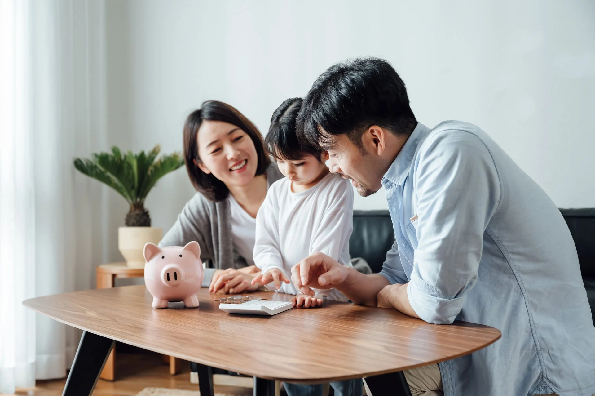 Parents teaching their child to save money.