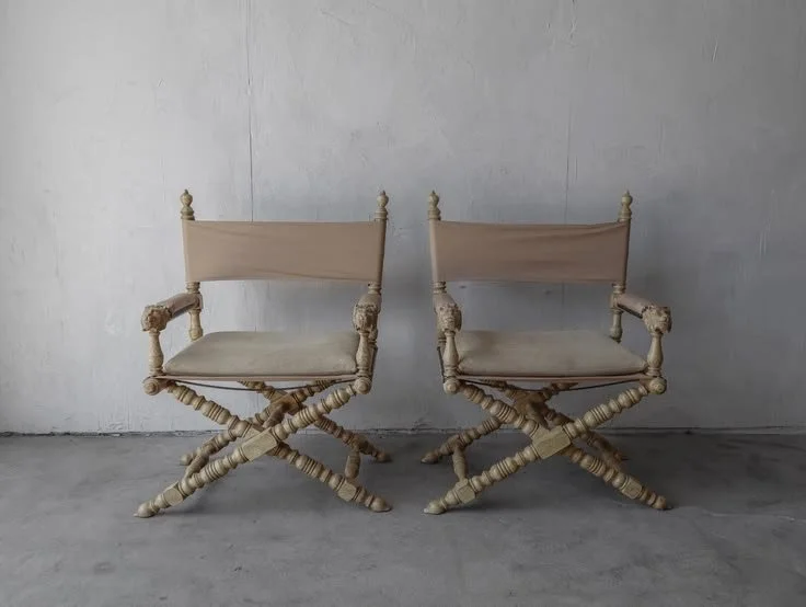 Têtes de Lion Campaign Director’s Chairs — Pair
Marge Carson · AgedModern / eBay
United States · 1970s
Dimensions: Approx. 29.5″ W × 24″ D × 39″ H each
Material/Finish: Carved wood with lion-head details; leather seat and back slings; suede seat pads
