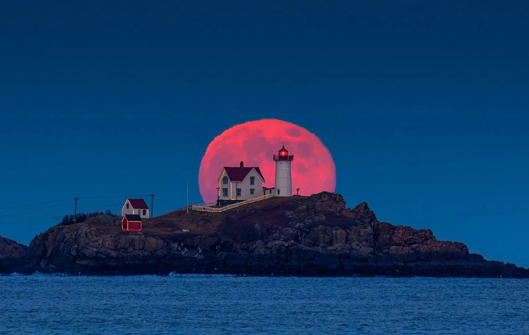 Cold Moon rising behind the Nubble Lighthouse by Rob Wright